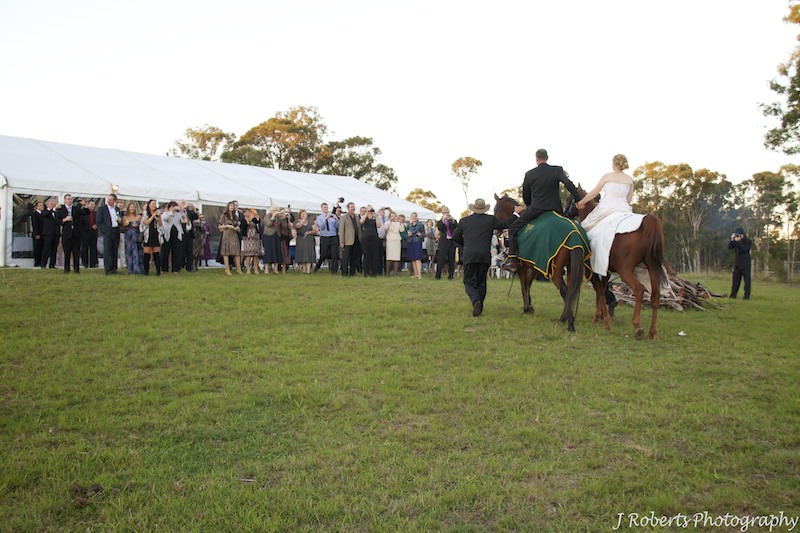 Bride and groom arriving at reception on horseback - wedding photography sydney